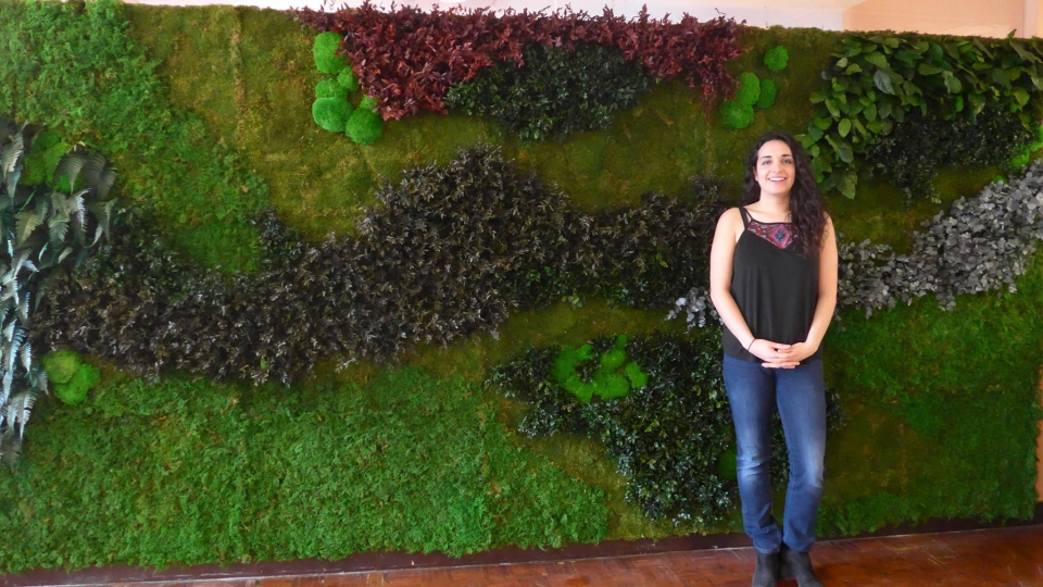 Today - image of student in front of the green wall