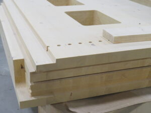 piece of mass timber with drilled holes and diecuts