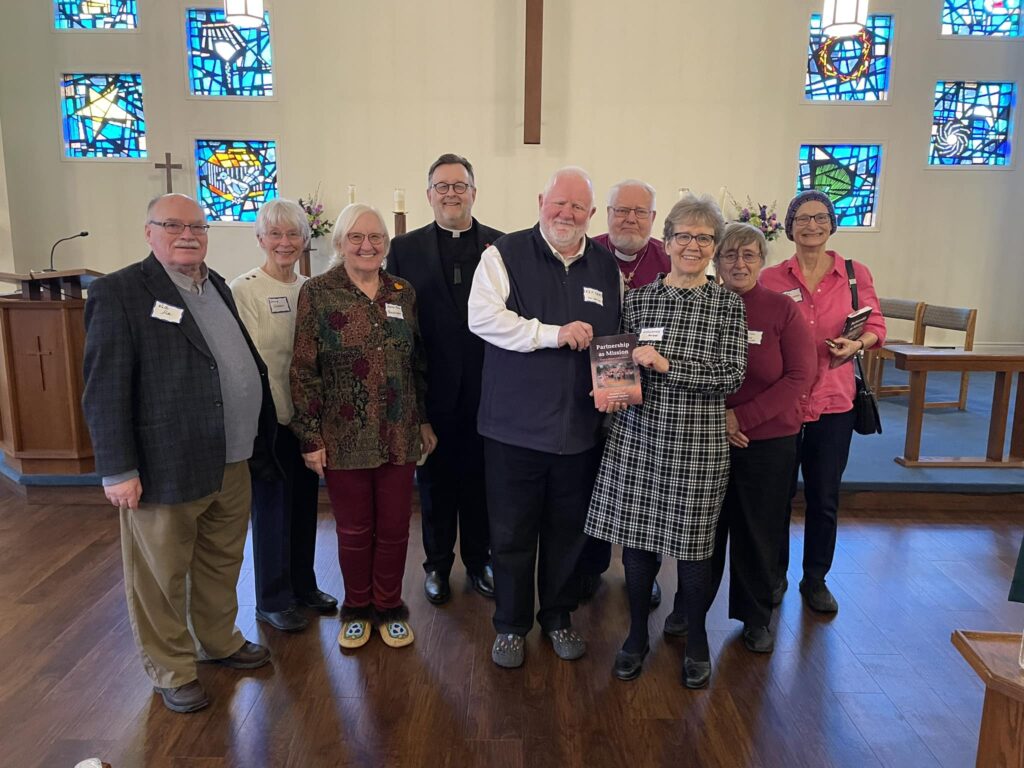 Group of people holding a book in a church.